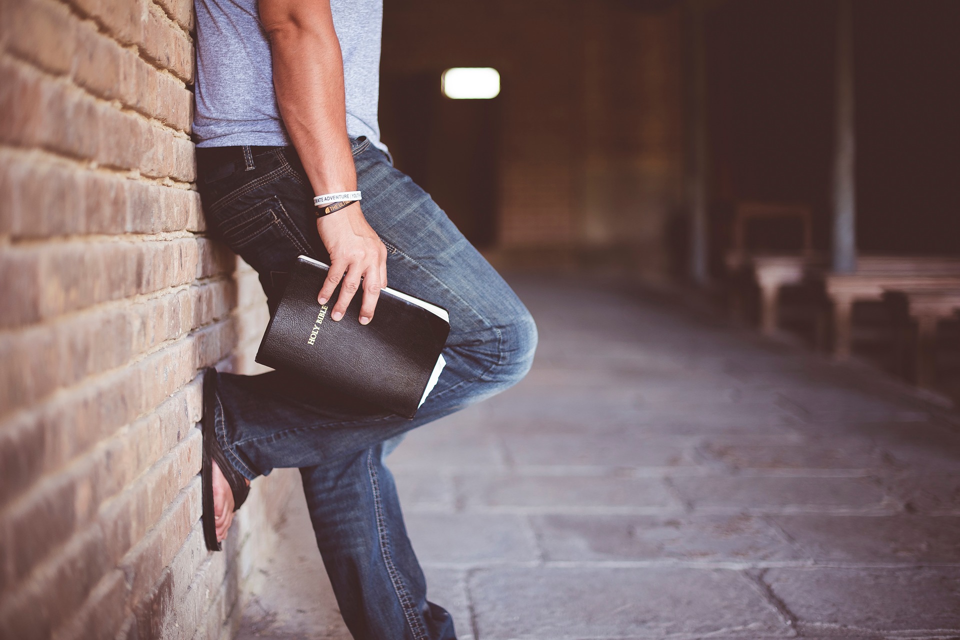 Leaning against wall with Bible